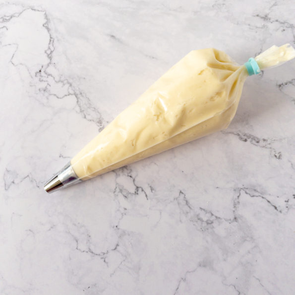 Piping bag filled with cream cheese frosting