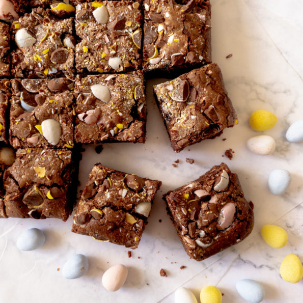 pan of mini egg brownies cut into square with bottom brownie pulled away