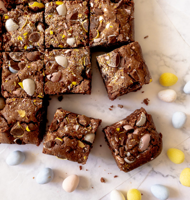 pan of mini egg brownies cut into square with bottom brownie pulled away