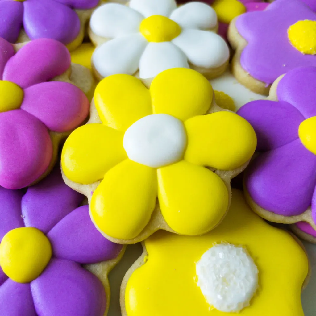 Close up of plate of decorated daisy shaped sugar cookies