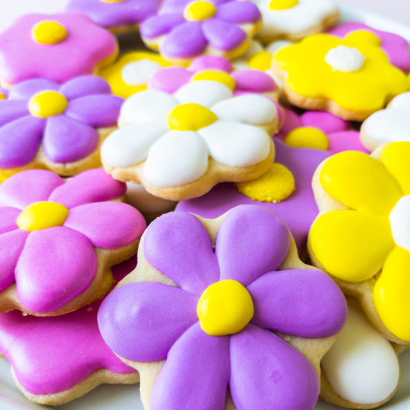 Daisy sugar cookies piled on a plate
