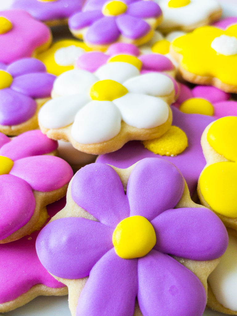 Daisy sugar cookies piled on a plate