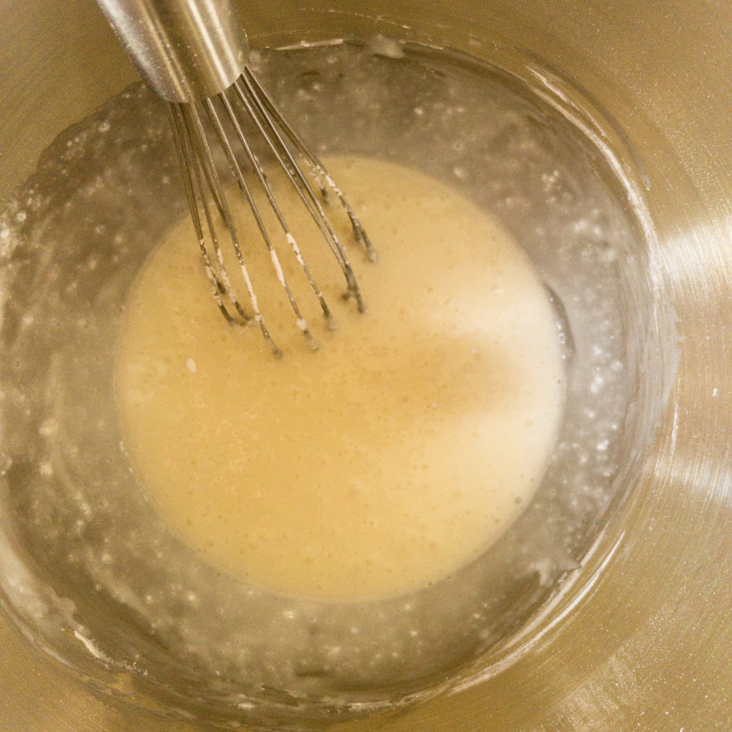 Royal icing ingredients in bowl with whisk