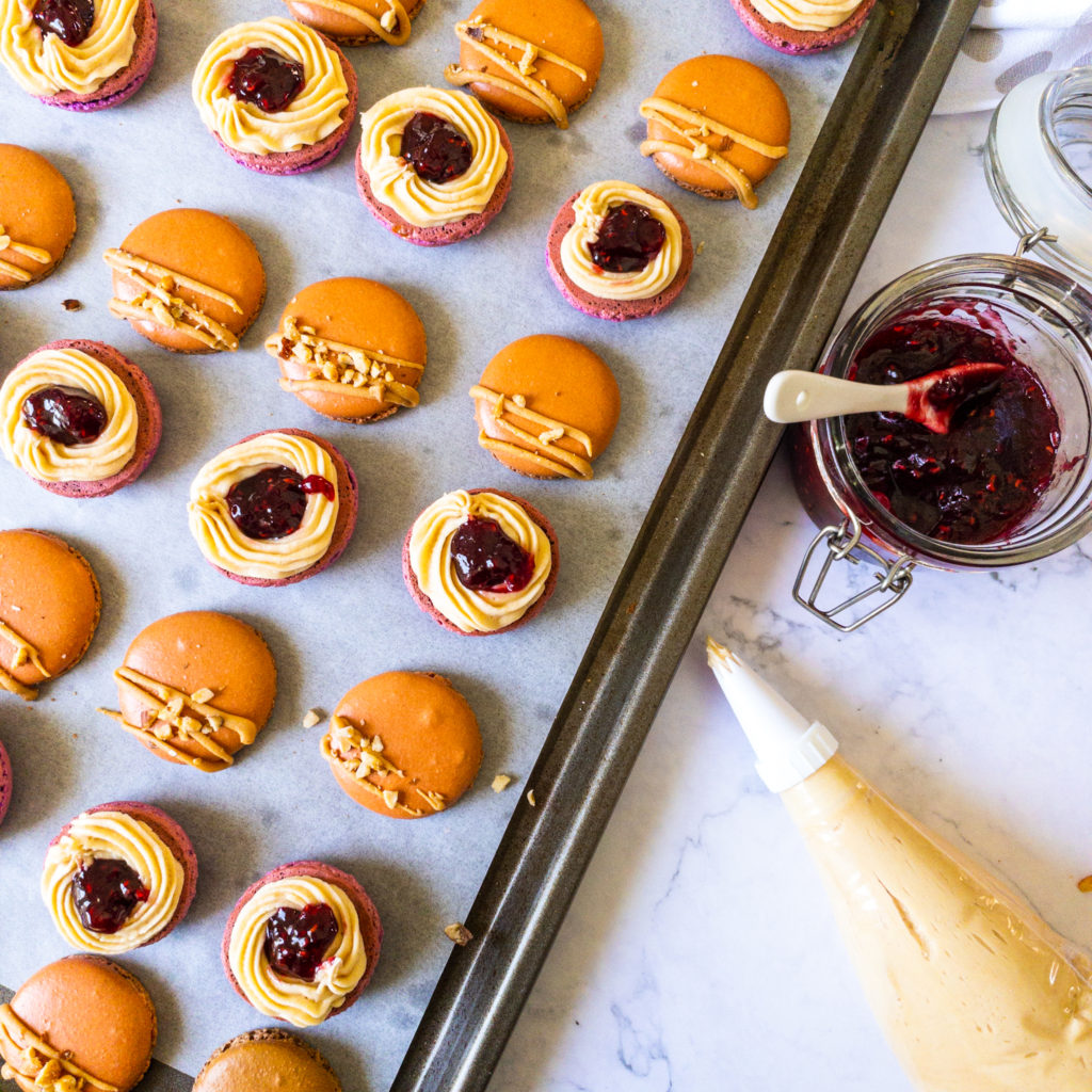 half assembled peanut butter and jelly macarons