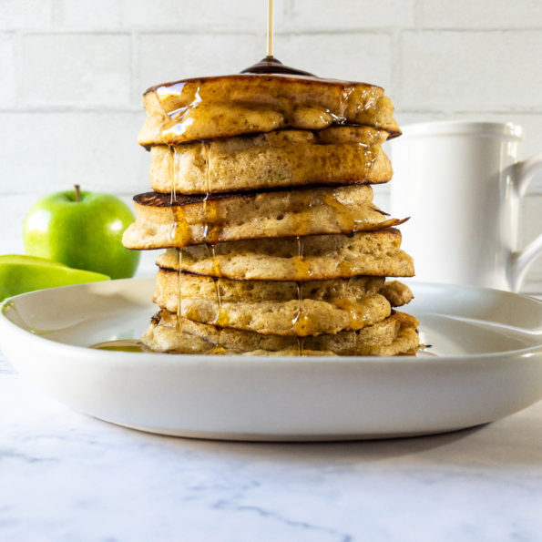 Stack of pancakes with syrup being drizzled on top