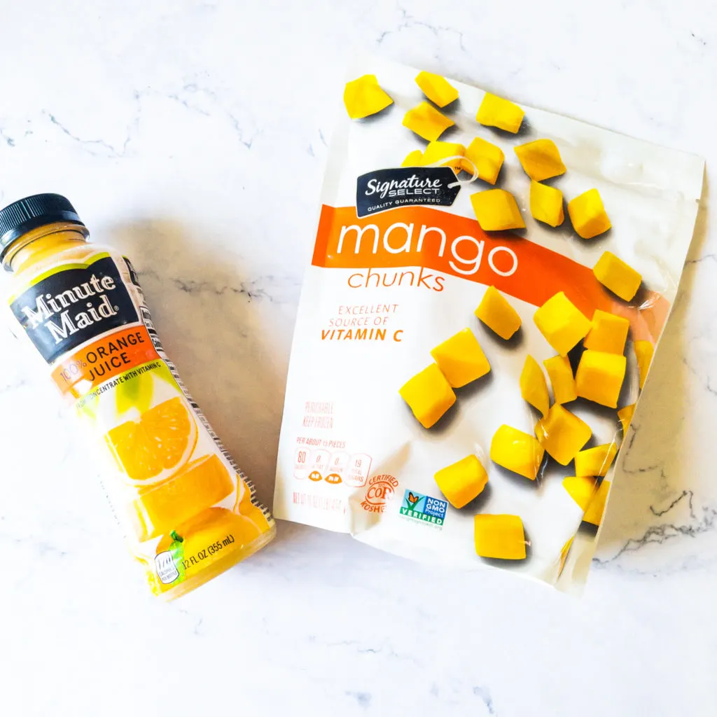 orange juice and frozen mango on bench