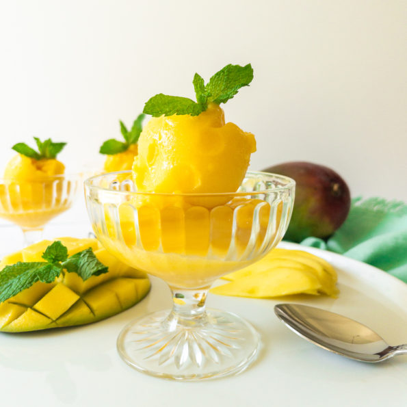 two scoops of mango sorbet in a glass